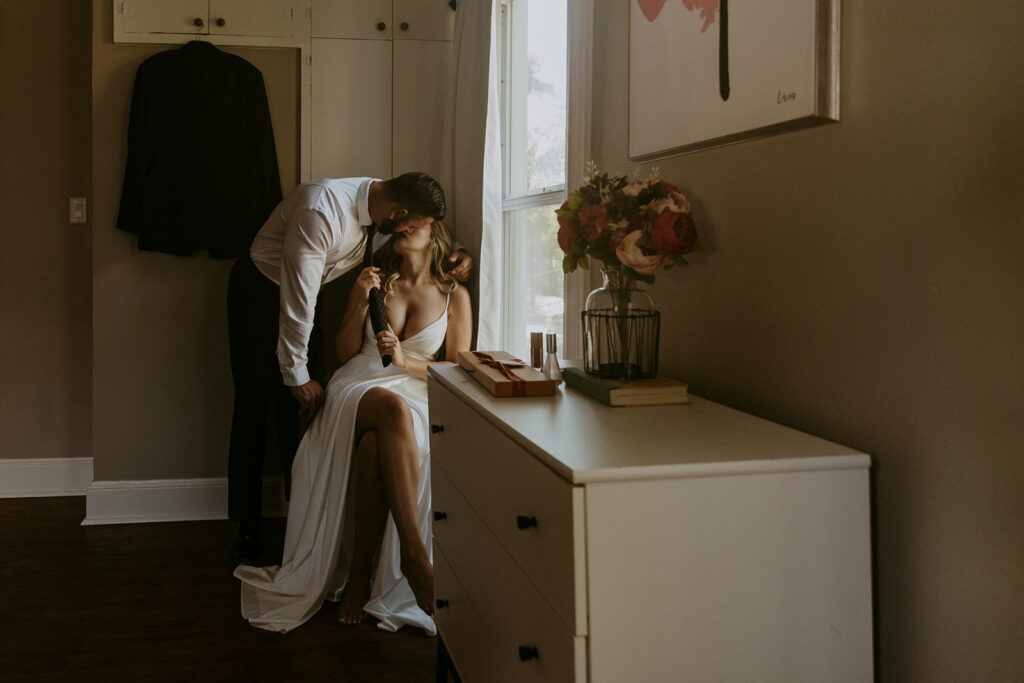 Couple helping each other get ready on their wedding day 