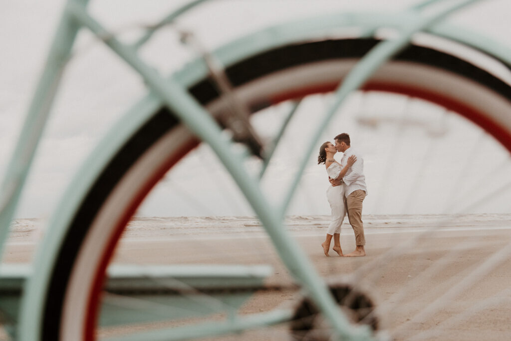 Creative Ideas For Engagement Photos | Couple riding a bike on the beach for their engagement 