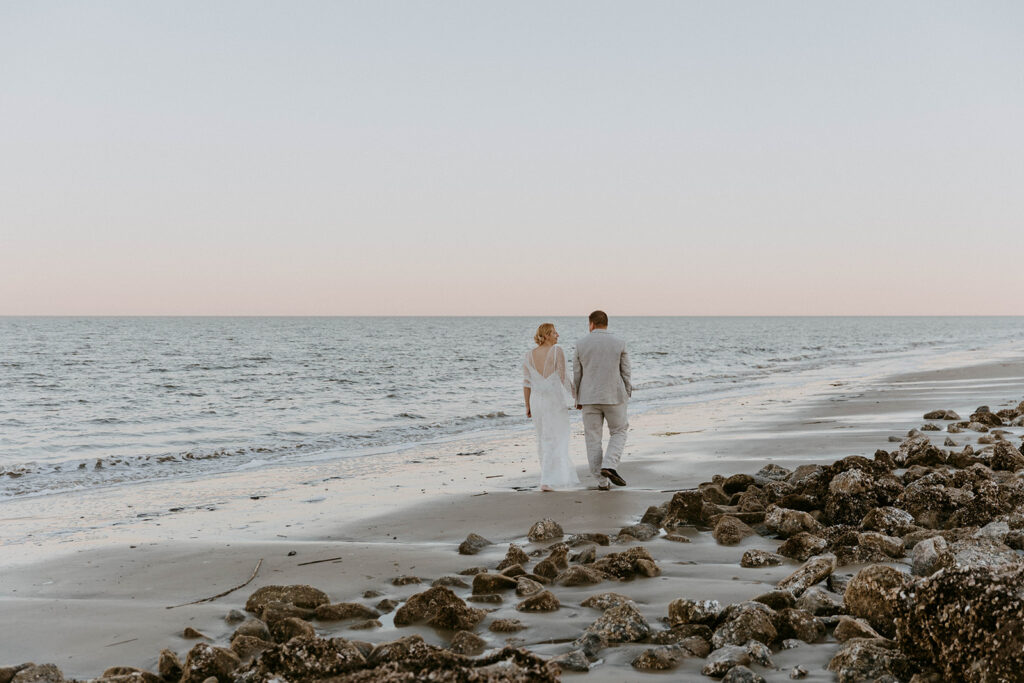 couple walking down the beach during wedding