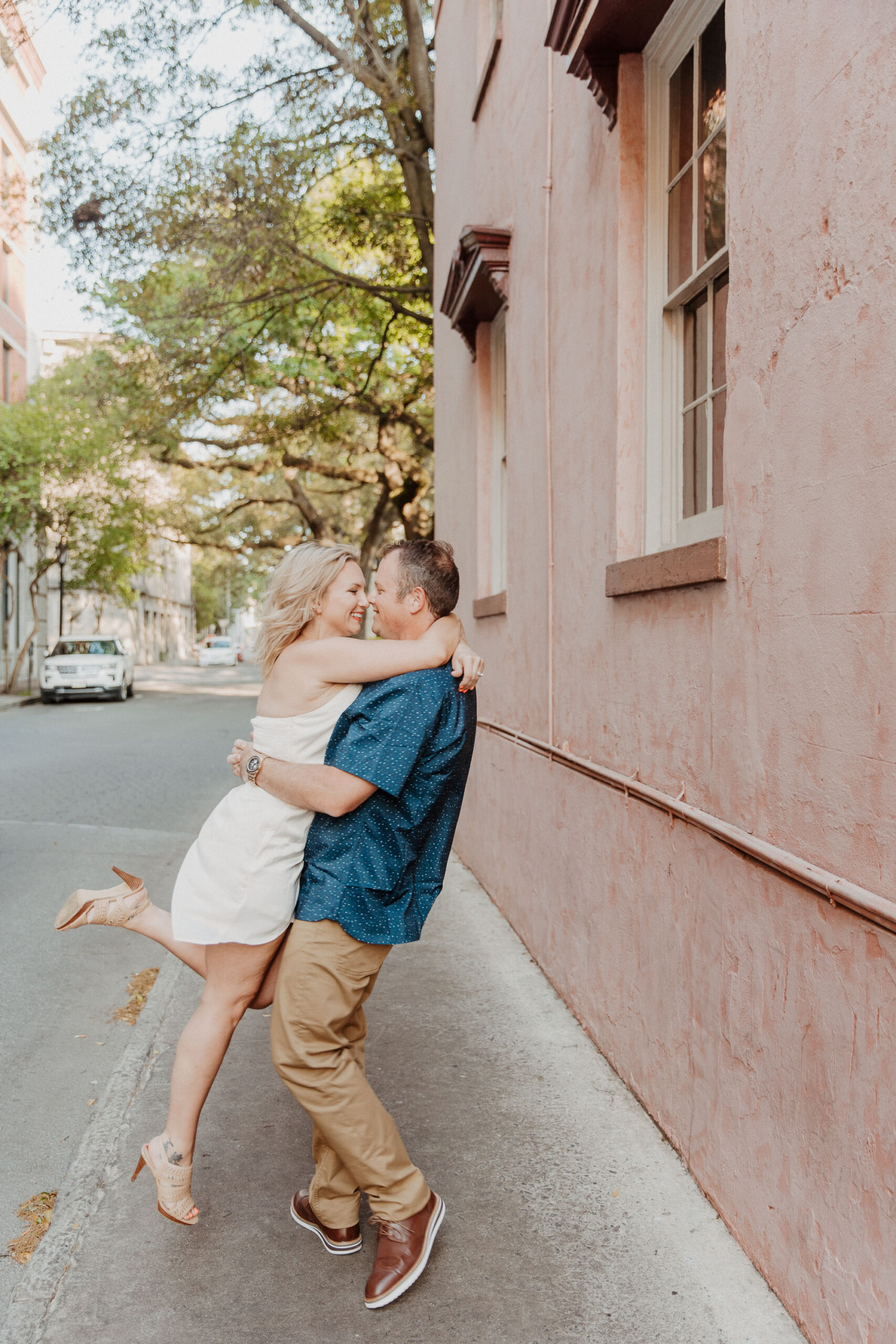 Couple sharing a romantic embrace on a city street at their anniversary photo session.