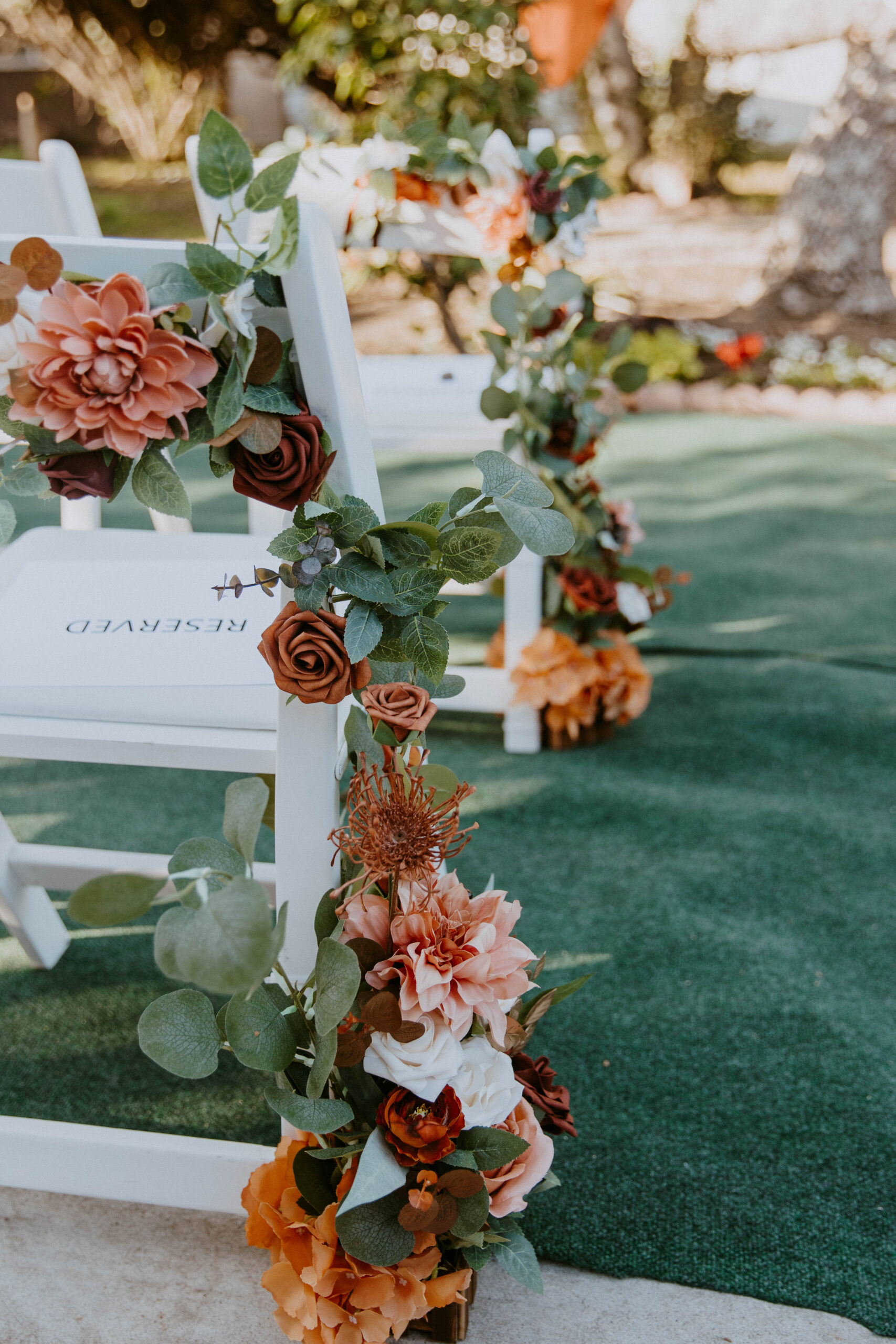 An outdoor setting decorated with fabric and flowers for an intimate backyard wedding.