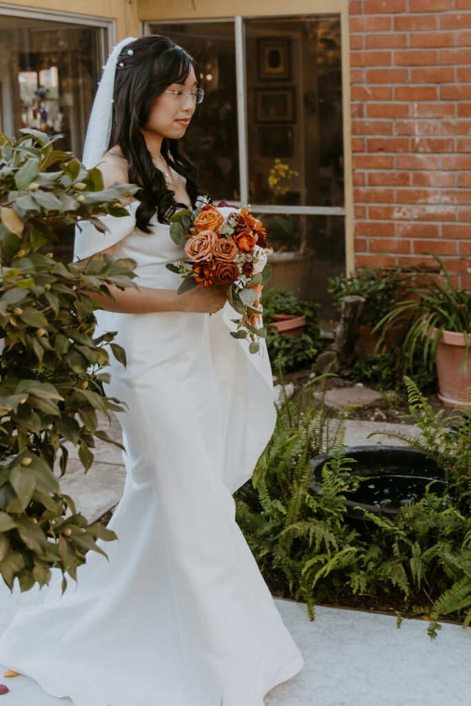 A bride in a white dress holding a bouquet of flowers.