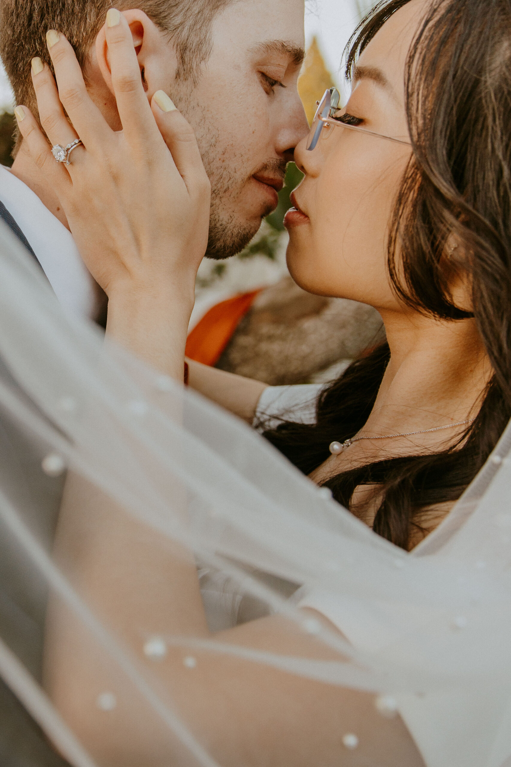 Close-up of an affectionate couple on their wedding day, about to kiss.