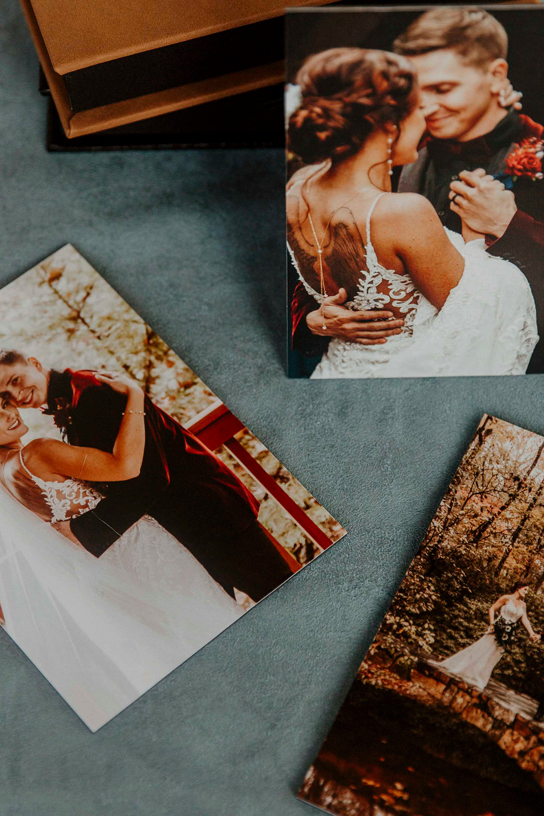 a Wedding keepsake with Three wedding photos featuring a bride and groom displayed on a gray surface, with a focus on tender, intimate moments 