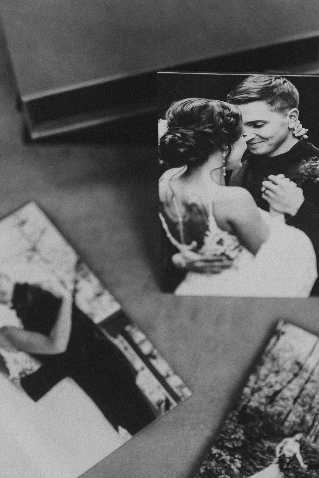 a Wedding keepsake with Three wedding photos featuring a bride and groom displayed on a gray surface, with a focus on tender, intimate moments 