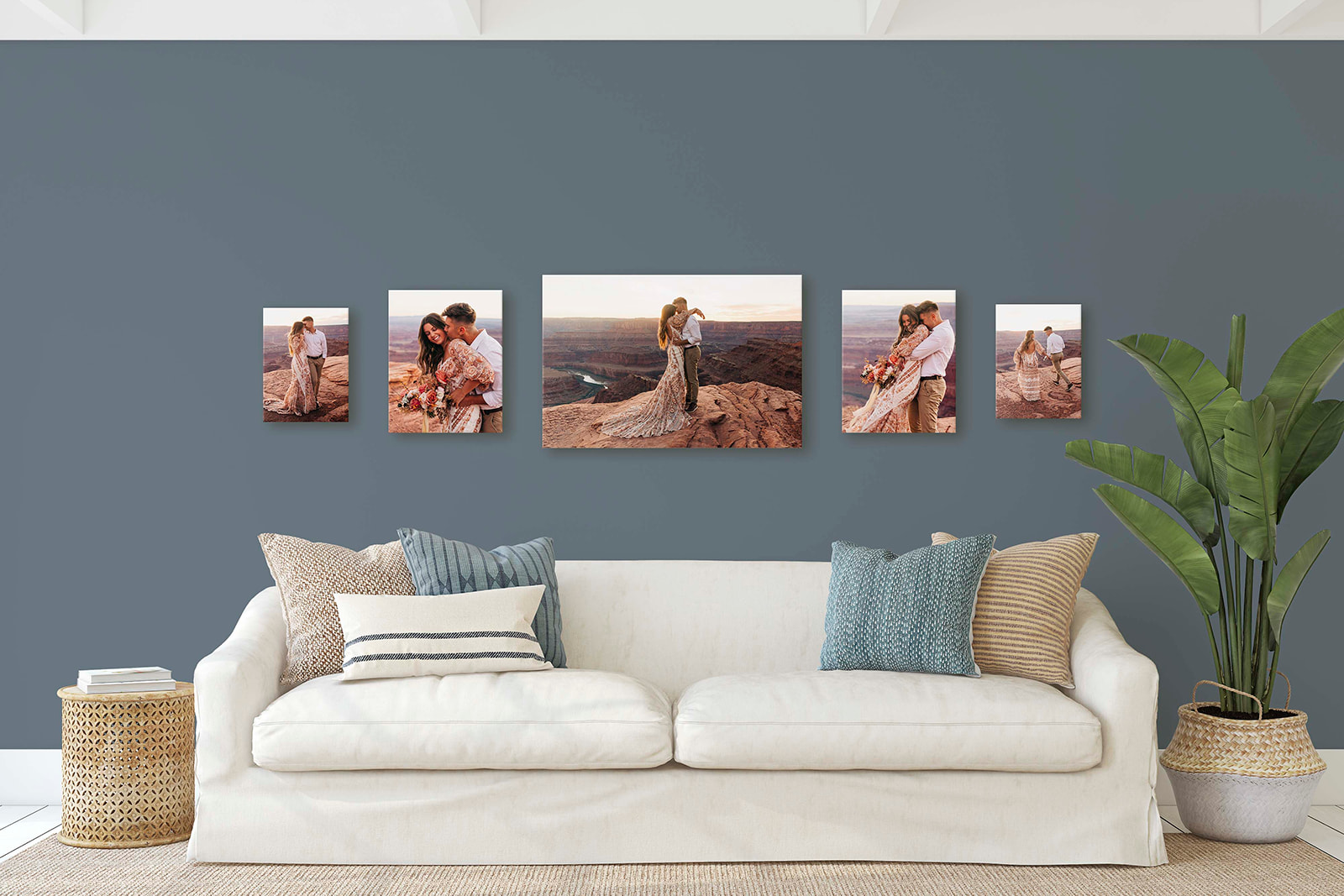 A living room wall featuring a series of five framed wedding photos above a white sofa with decorative pillows and a plant beside it.