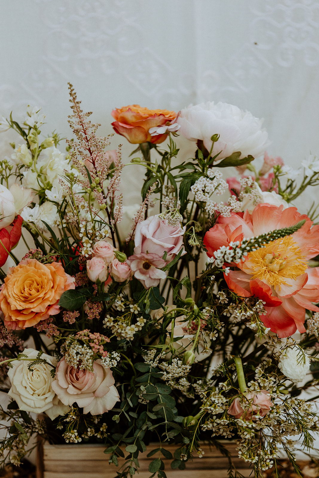 A table set outdoors with floral centerpieces, white plates, glassware, and neatly arranged cutlery, surrounded by lush greenery at Wildflower 301