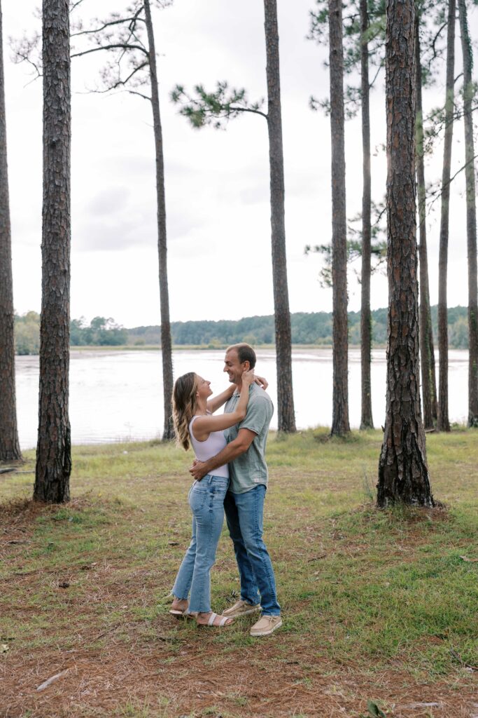 A man and woman embracing in the woods. 