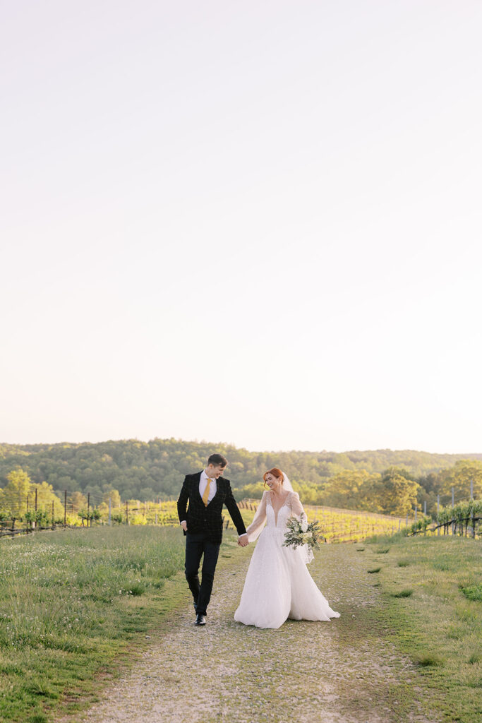 cute couple holding hands walking around their wedding venue