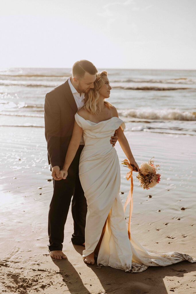 portrait of the groom kissing the bride on the cheek
