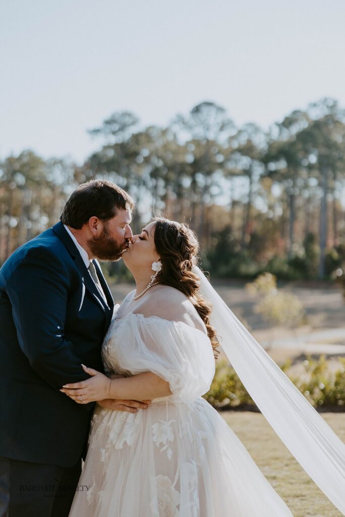 portrait of the bride and groom kissing after their first look