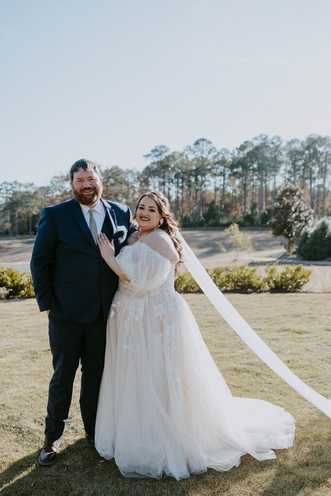 cute couple smiling at the camera during their bridal portraits 
