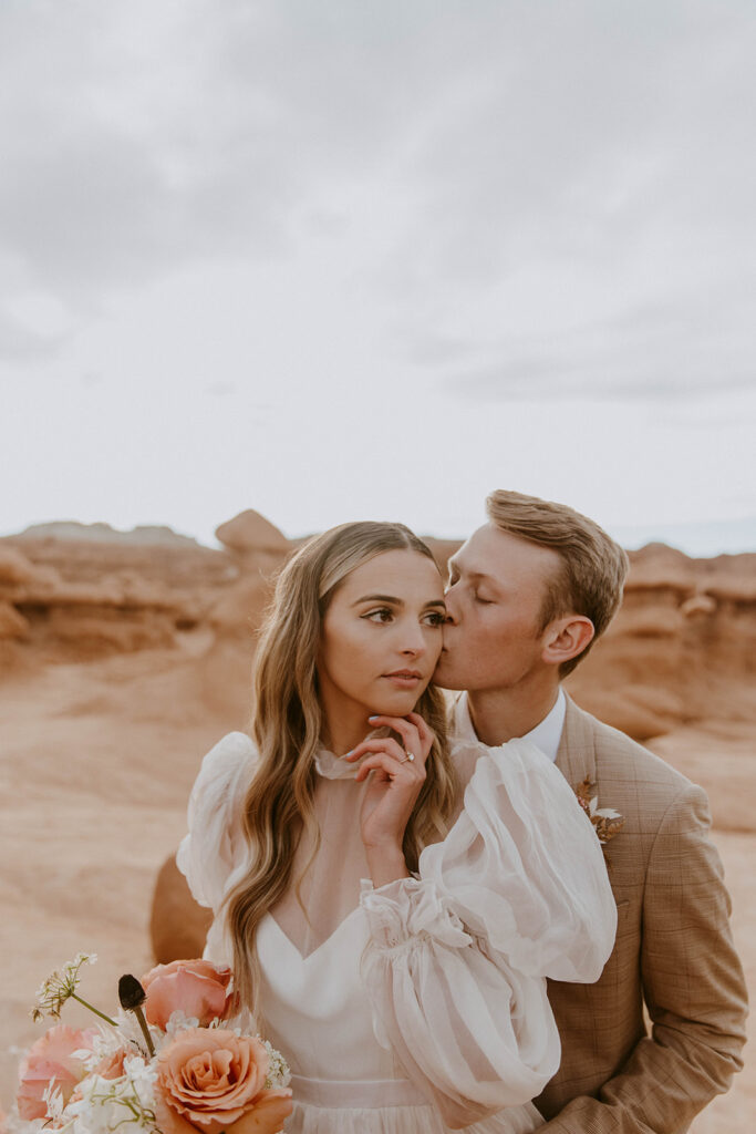 groom kissing the bride on the cheek