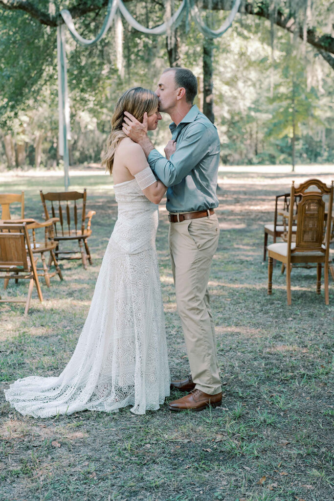 cute picture of the groom kissing the bride on the forehead 