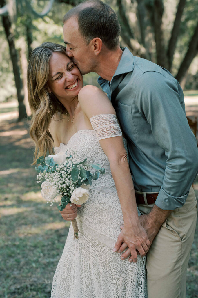 picture of the groom kissing the bride on the cheek
