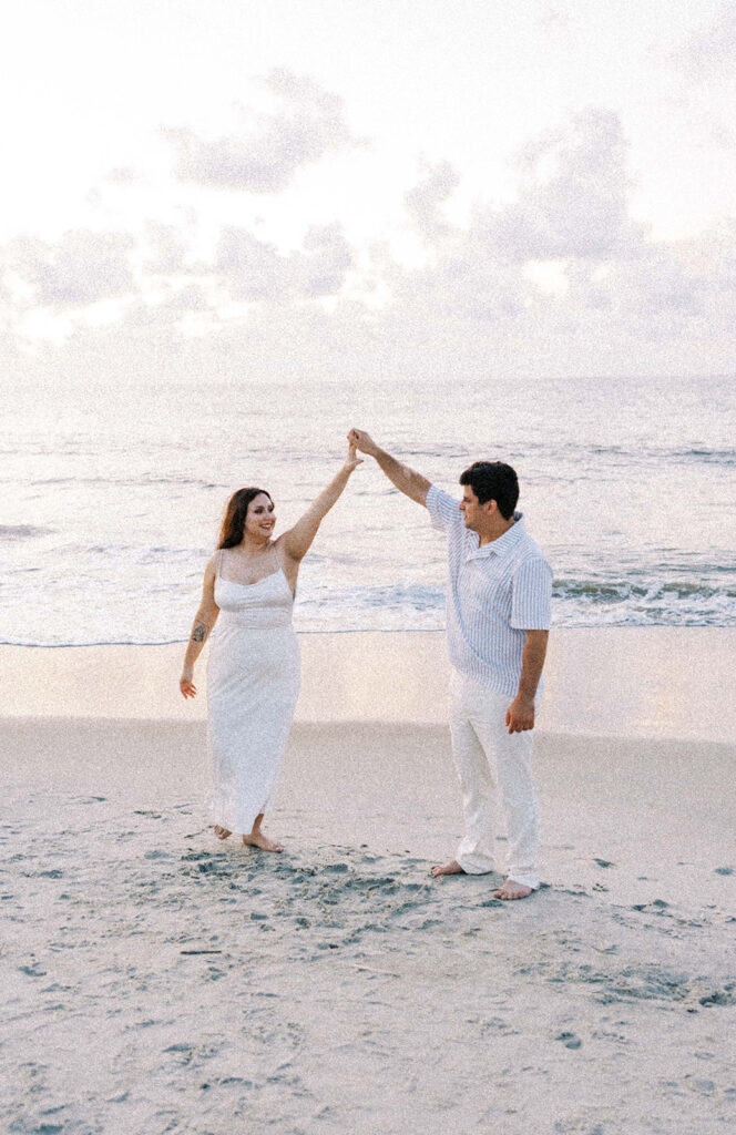 cute couple dancing at the beach during their photoshoot