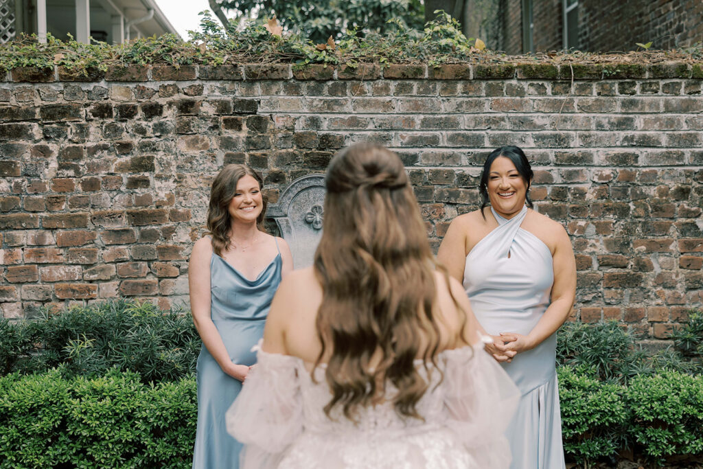 bride at her first look with her bridesmaids