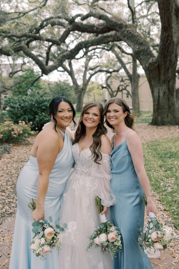 bride and her bridesmaids smiling at the camera