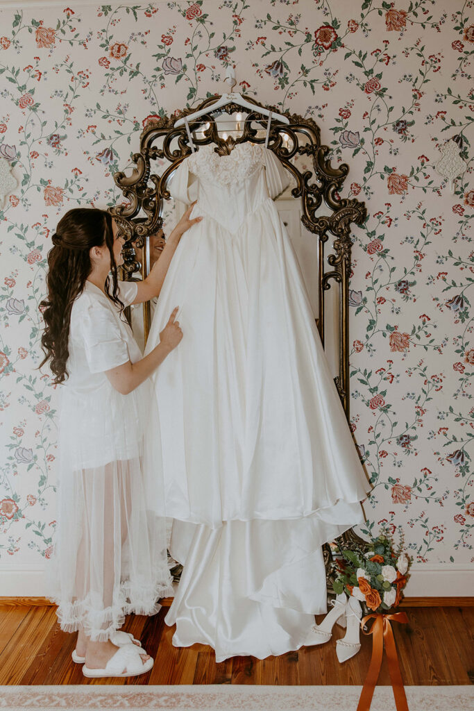 cute picture of the bride next to her wedding dress