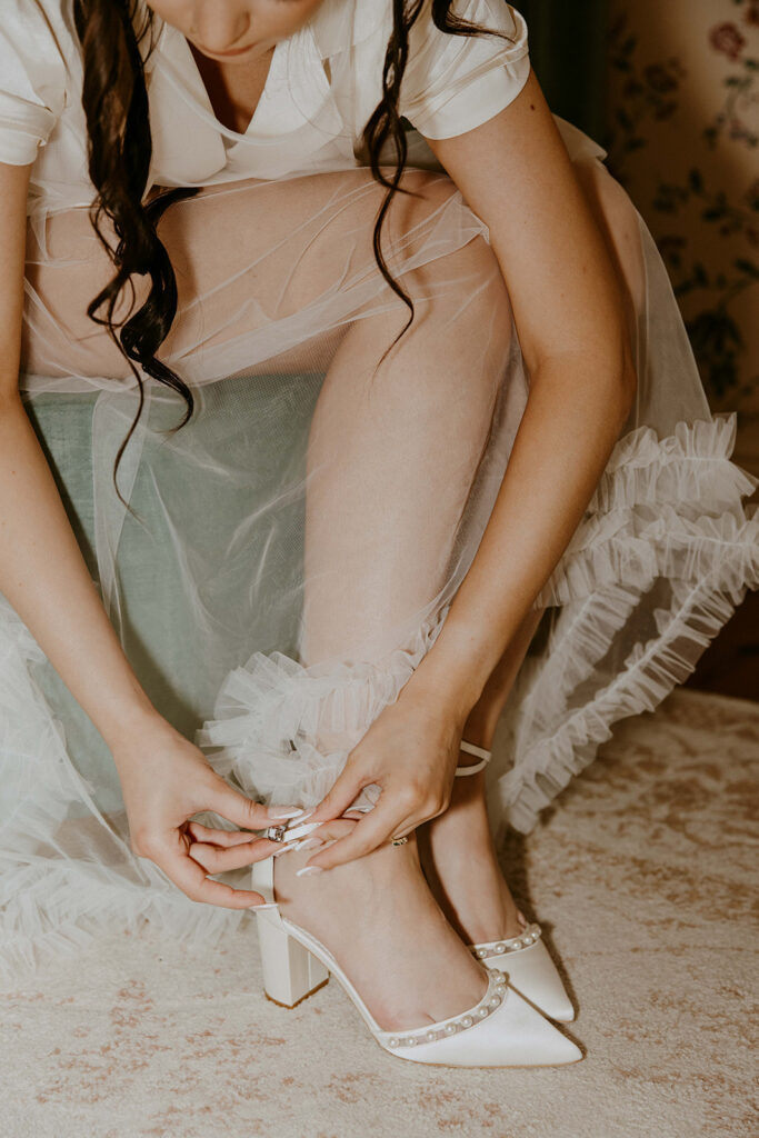 bride putting on her wedding shoes