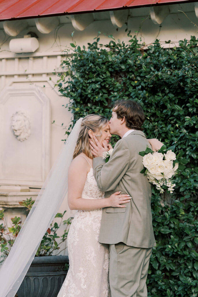 groom kissing the bride on the forehead 