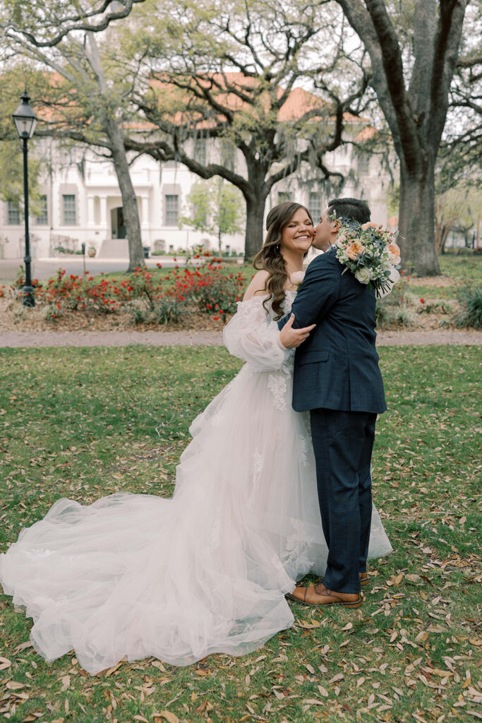 groom kissing the bride on the cheek