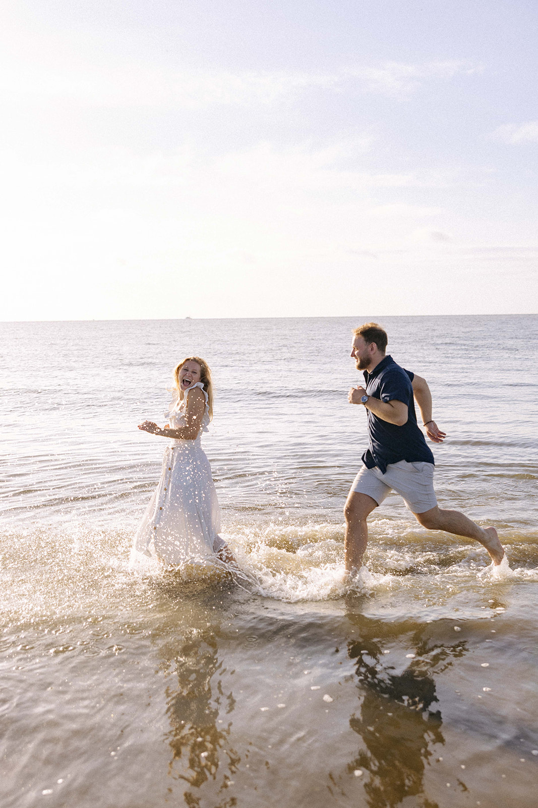 couple playing at the beach during their photoshoot