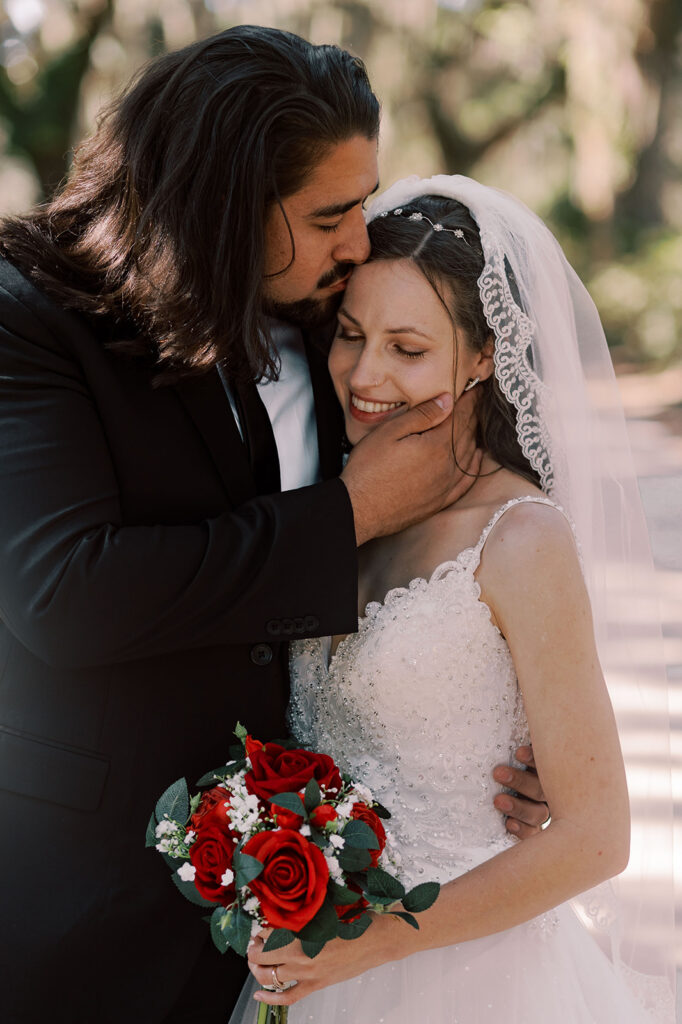 Groom, kissing the bride on the forehead