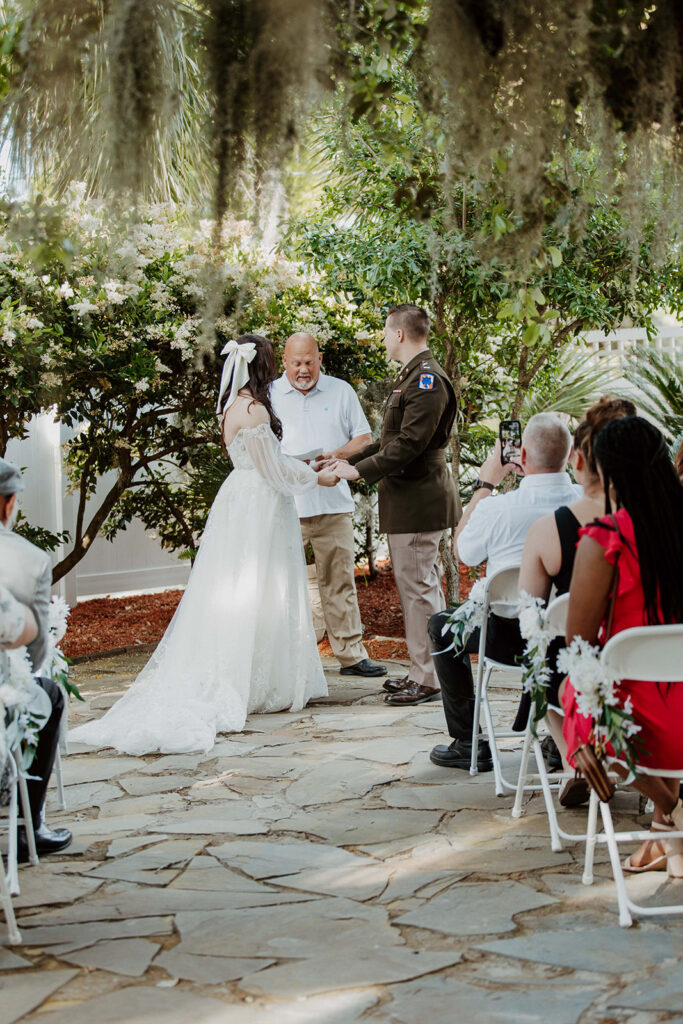 Bride and groom holding hands during their intimate wedding ceremony