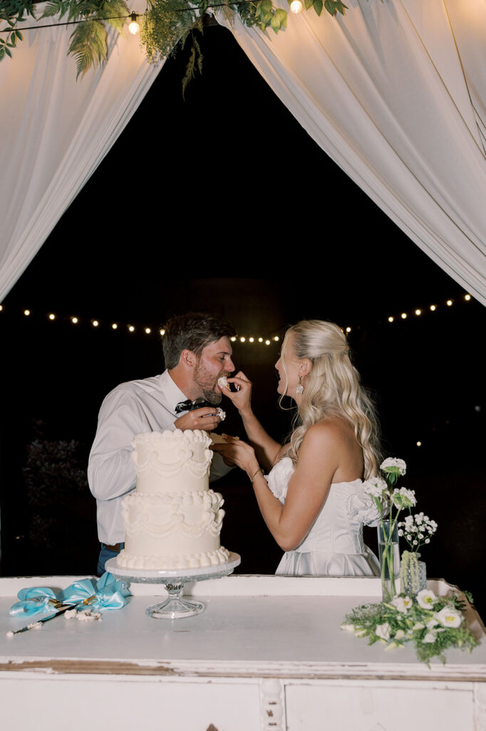 Newly married couple cutting their wedding cake