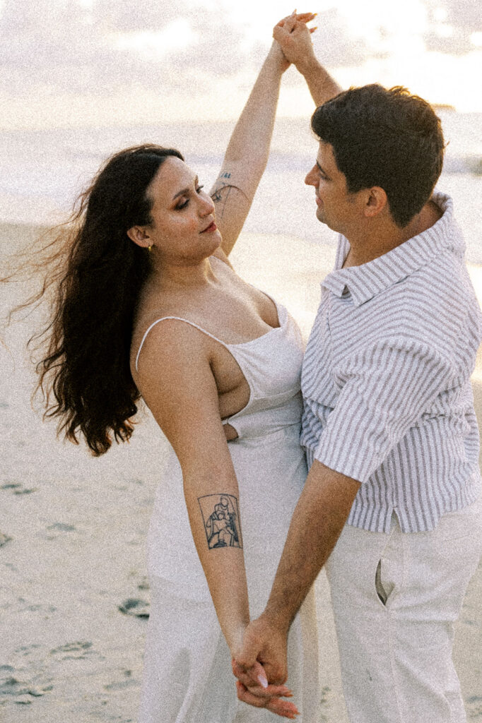 couple smiling at each other during their beach photoshoot
